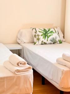 a room with a bed with a pillow and towels at Penthouse near cathedral private rooftop Private Parking in Seville +55 photos