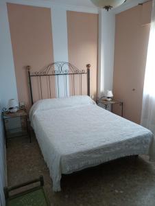 een slaapkamer met een groot bed met een metalen hoofdeinde bij Edificio tarifa playa in Tarifa