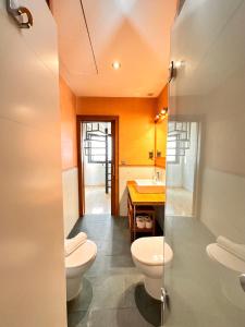 ein Badezimmer mit 2 WCs und einem Waschbecken in der Unterkunft Penthouse near cathedral private rooftop Private Parking in Sevilla