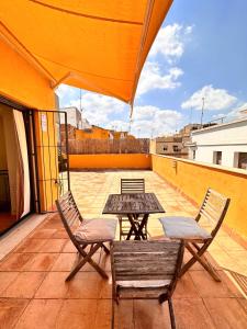 eine Terrasse mit einem Tisch und Stühlen auf dem Dach in der Unterkunft Penthouse near cathedral private rooftop Private Parking in Sevilla