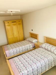 um quarto com duas camas num quarto em Un coin de tranquillité en plein cœur de l'action em Al Hoceïma