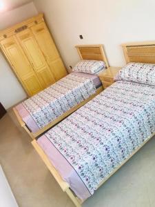 deux lits côte à côte dans une pièce dans l'établissement Un coin de tranquillité en plein cœur de l'action, à Al Hoceïma