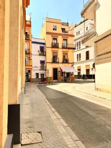 eine leere Straße in einer Stadt mit Gebäuden in der Unterkunft Penthouse near cathedral private rooftop Private Parking in Sevilla
