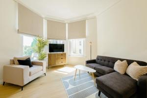 uma sala de estar com um sofá e uma cadeira em Grange Rd Flat 1 one bedroom flat em Bristol