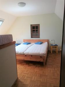 a bedroom with a large wooden bed with blue pillows at An der Weinstraße - Idyllisches Ferienhäuschen im Naturparadies umgeben von Wiesen & Wäldern! in Zgornja Kungota