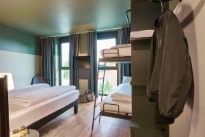 a room with three bunk beds and a window at Ibis Styles Singen in Singen