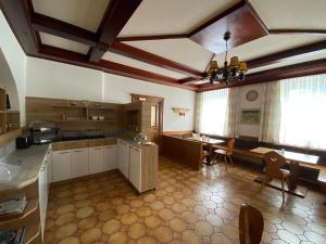 Pension Eder في Selzthal: مطبخ كبير مع طاولة وغرفة طعام