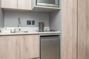 eine kleine Küche mit Spüle und Mikrowelle in der Unterkunft City Chic Studio, Cape Town in Kapstadt + 1 Foto