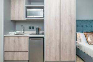 eine kleine Küche mit Spüle und Mikrowelle in der Unterkunft City Chic Studio, Cape Town in Kapstadt