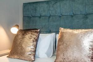 zwei Kissen auf einem Bett mit grünem Kopfteil in der Unterkunft City Chic Studio, Cape Town in Kapstadt