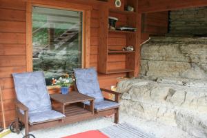 2 Stühle und ein Tisch auf der Veranda einer Hütte in der Unterkunft Natura Sauna in Laulasmaa