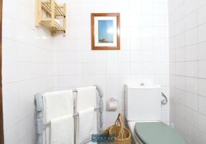 a bathroom with a toilet and towels on the wall at MyStay - Mértola Castelo Palace in Mértola