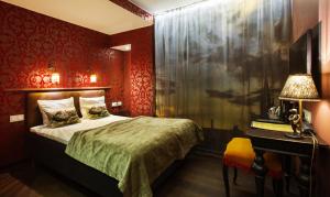 a bedroom with red walls and a bed and a desk at Skanstulls Boutique Hostel in Stockholm