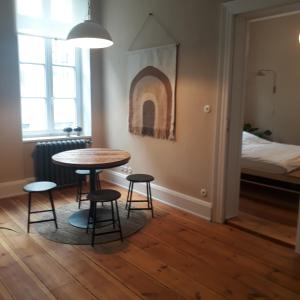 a room with a table and two stools and a bed at Stadtvilla An der Viergelindenbrücke in Rostock