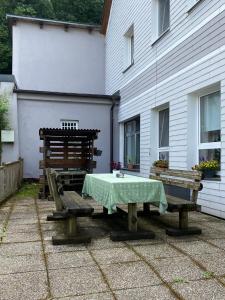 einem Tisch und zwei Bänken vor einem Gebäude in der Unterkunft Pension Eder in Selzthal