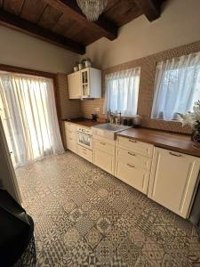 a kitchen with white cabinets and a tile floor at Kouzelný domeček in Ostrava