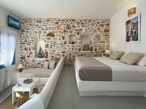 um quarto com 2 camas e uma parede de pedra em Sirocos em Karavostasi