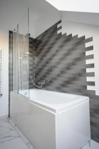 baño con bañera blanca y escalera en Popa Apartment, en Cluj-Napoca