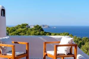 para krzeseł siedzących na balkonie z widokiem na ocean w obiekcie Large Villa on Ibiza West Coast with pool & sunset view - Nirvana w mieście Cala Tarida