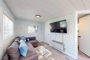 a living room with a couch and a flat screen tv at The Lighthouse Cottage Four in Wasaga Beach