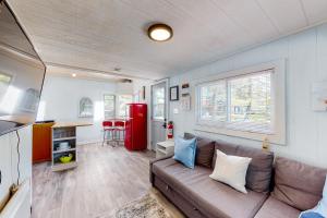a living room with a couch and a red refrigerator at The Lighthouse Cottage Four in Wasaga Beach
