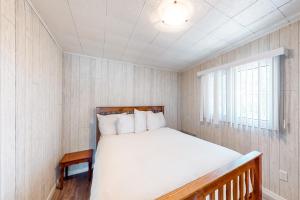 a bedroom with a bed and a window at The Dockhouse Cottage Five in Wasaga Beach +16 photos