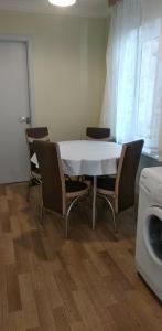 a table and chairs with a white table and a washing machine at уют in Rustavi