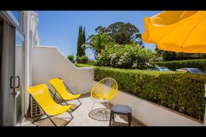 - un balcon avec des chaises et un parasol dans l'établissement Ocean Oasis by LovelyStay, à Albufeira