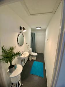 baño con lavabo, espejo y alfombra azul en LillasLavender Kurzeme, en Ošenieki