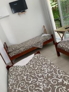 two beds in a room with a tv on the wall at LamijaApartmani in Sutomore