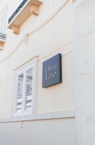 a sign on the side of a building with a window at Dear Faro - Guest House in Faro