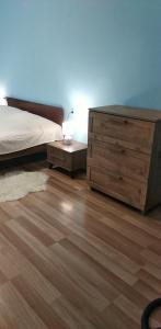 1 dormitorio con cama y tocador de madera en уют en Rustavi
