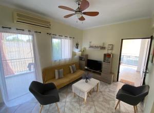 een woonkamer met een bank en 2 stoelen bij Sunny Apartment Amaliada in Amaliás