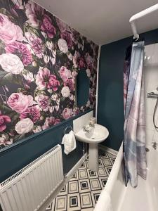 a bathroom with a flower wallpaper and a sink and tub at Modern 2 bed apartment in Bristol city centre in Bristol