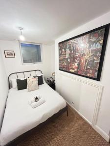 a bedroom with a white bed with a large painting on the wall at Modern 2 bed apartment in Bristol city centre in Bristol