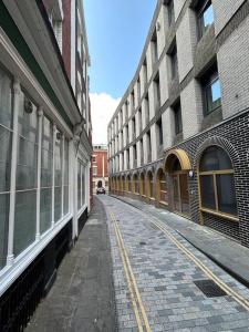 an empty street in a city with tall buildings at Modern 2 bed apartment in Bristol city centre in Bristol