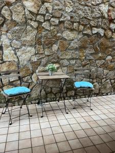 stół i dwa krzesła przed kamienną ścianą w obiekcie Casa vacanza Luna w mieście Orte