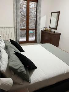 sypialnia z łóżkiem z poduszkami i oknem w obiekcie Casa vacanza Luna w mieście Orte