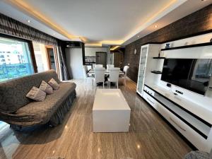 a living room with a couch and a flat screen tv at Penthouse 4 bedrooms, 1 living room, to the sea 7 minutes walk in Alanya