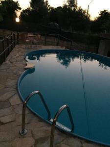 ein großer blauer Pool mit einem Steingang um ihn herum in der Unterkunft Villetta Beatrice in Noto