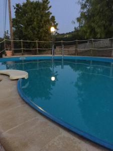ein großer blauer Pool mit Straßenlicht daneben in der Unterkunft Villetta Beatrice in Noto