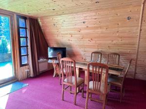 uma sala de jantar com uma mesa e cadeiras e uma televisão em Alpine chalet NIRVANA em Borovets