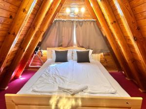 a bed in a wooden cabin with a window at Alpine chalet NIRVANA in Borovets