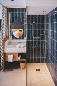 a bathroom with a tub and a sink and a mirror at TILL Naturhotel - Self-Check-In in Satteins