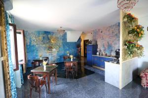 una cucina con pareti blu e tavoli e sedie in legno di B & B L'almanacco a San Martino In Strada