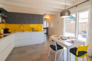 uma cozinha com armários brancos e uma mesa e cadeiras em Vicino alla Villa Palladiana La Rotonda! Duplex Apartment em Vicenza