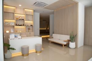 a lobby with a white reception desk and a couch at J & L Residence and Spa in Ban Khlong Khwang Klang