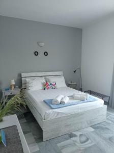 Un dormitorio blanco con una cama con toallas. en Kantouni Guest House by the sea, en Batsi