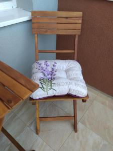 uma cadeira de madeira com uma almofada em cima em Апартамент White apartment град Китен em Kiten