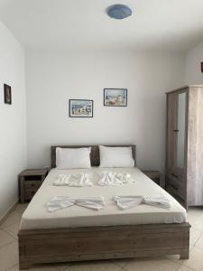 a large bed with white sheets and pillows on it at Avdikos House in Parga